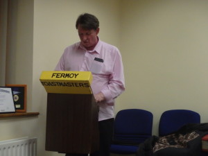  Tim Fitzgerald stands at the lectern delivering his overall impression as General Evaluator of the meeting. 